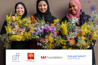 Three smiling women holding colourful flower bouquets, above logos for philanthropic organisations including Siddle Family Foundation, English Family Foundation, Westpac Foundation and Philanthropy Australia.